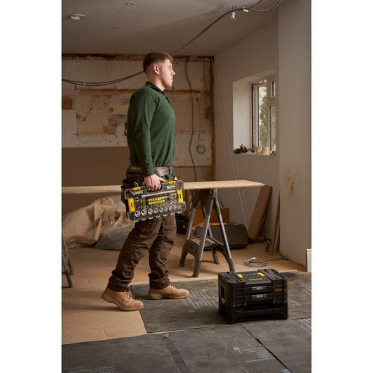 STANLEY FMMT98103-1 tool organizer with clear compartments held by person in work clothes on jobsite.