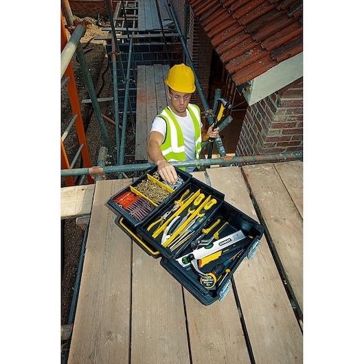 STANLEY FMST1-71219 toolbox open on construction site with assorted hand tools and fasteners.
