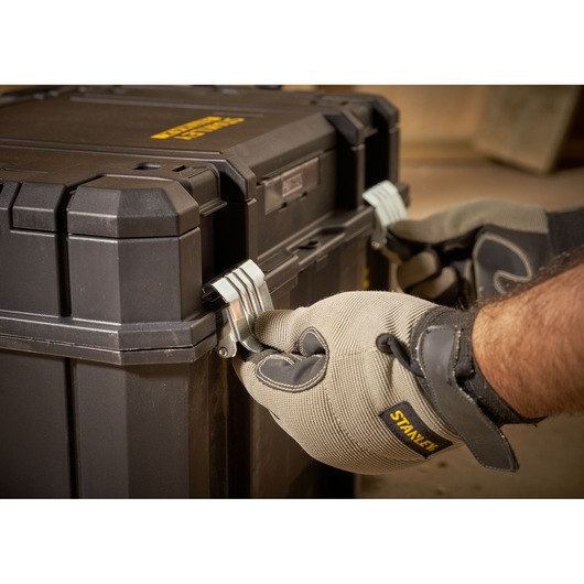 STANLEY FMST1-75796 toolbox close-up, gloved hands locking metal latches, product photography.