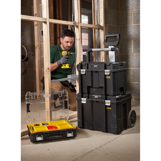 STANLEY FMST1-75796 black modular mobile tool boxes with yellow accents and transparent organizer, shown on a construction site.