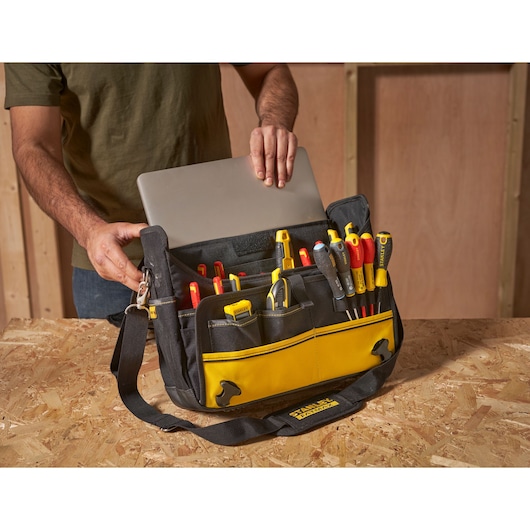STANLEY FMST1-80149 tool bag filled with tools and a laptop, front angle on workbench.