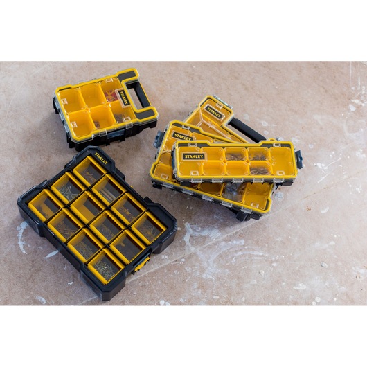 STANLEY FMST81077-1 organizer boxes with yellow compartments on a workshop floor, photography, top view.