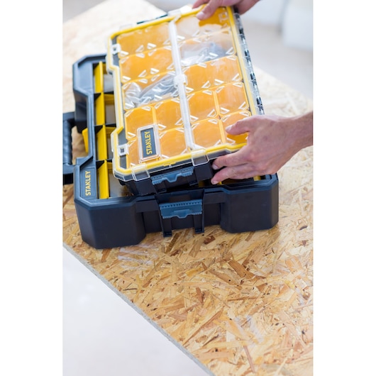 STANLEY FMST81077-1 organizer with clear lid and yellow compartments, shown on a workbench.