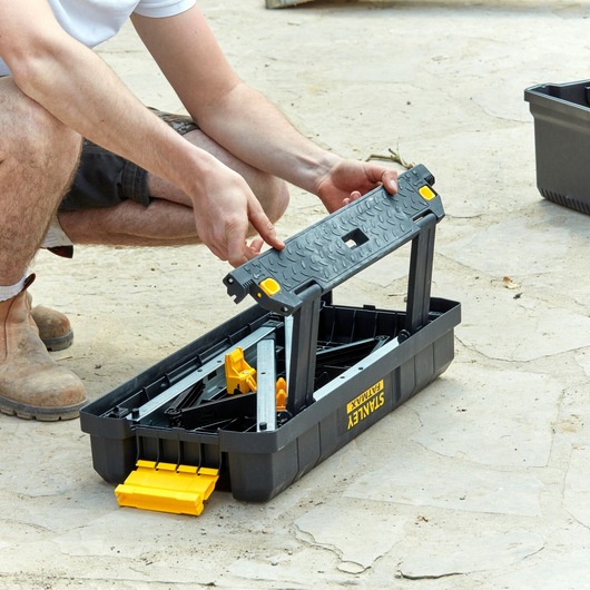 STANLEY FMST81083-1 black and yellow foldable toolbox with handle, shown partially open outdoors.
