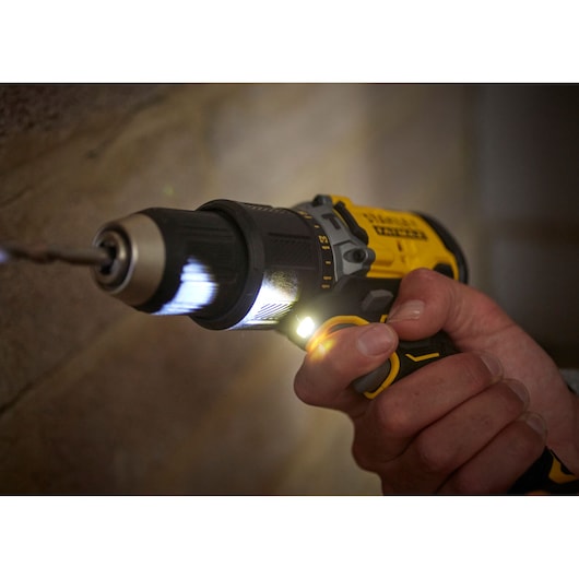 STANLEY SFMCD715D2F cordless drill with LED light in use close up, drilling into a wall.