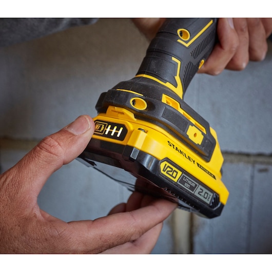 Photo of STANLEY SFMCD715D2K cordless drill, close-up of yellow and black handle and V20 battery.