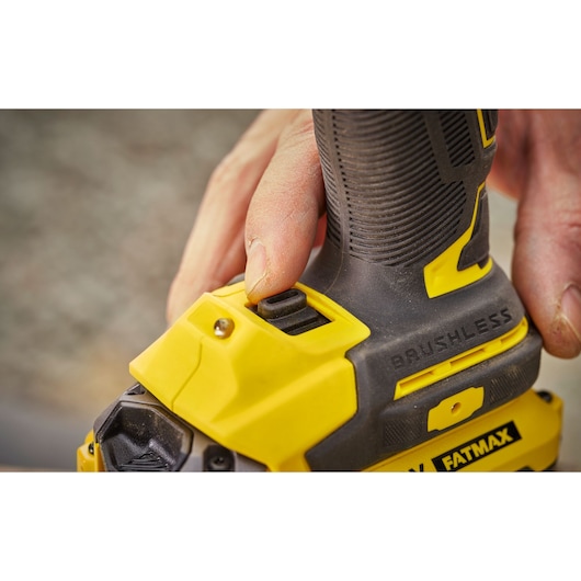 STANLEY SFMCF920B brushless drill close-up, yellow and black handle, hand pressing button.