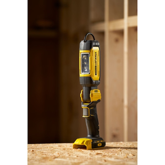 STANLEY SFMCL050B 18V FATMAX V20 Pivot Light, yellow-black LED work light, shown upright on wood surface.