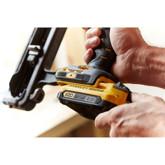 Photo of STANLEY SFMCN616D2K cordless nailer V20 with 2.0Ah lithium-ion battery held in hand.