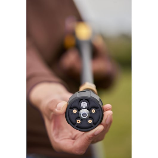 STANLEY SFMCPC93B pressure washer nozzle close-up held by hand outdoors.