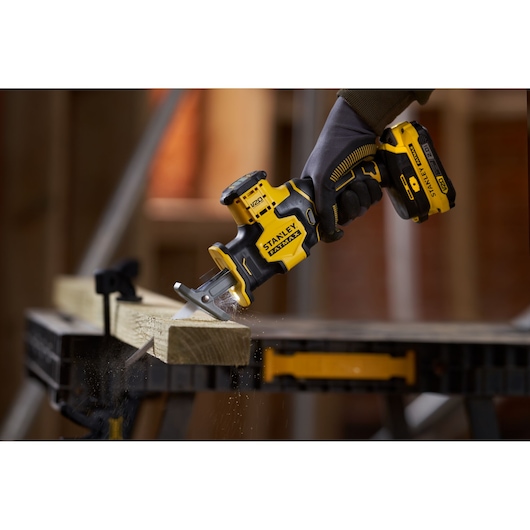 STANLEY SFMCS305B cordless reciprocating saw cutting wood, close-up photography of product in use.
