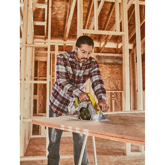 STANLEY SFMCS550B cordless circular saw cutting plywood in construction setting.