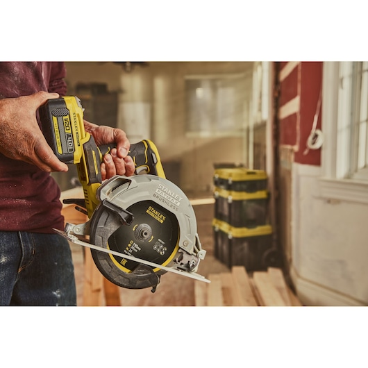 Stanley SFMCS550M2K brushless cordless circular saw held in hand, construction setting.