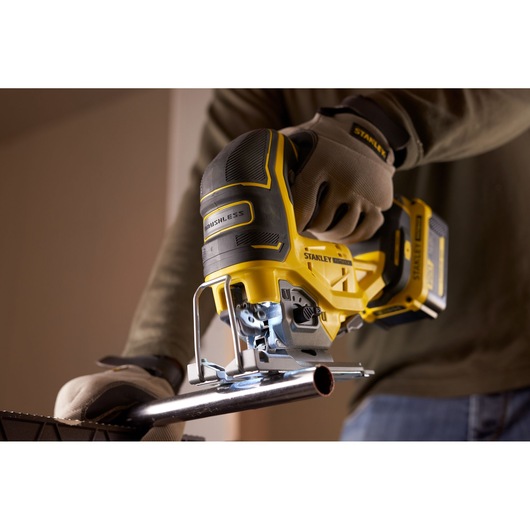 STANLEY SFMCS650B 18V FATMAX V20 brushless jigsaw cutting metal pipe, close-up photography.