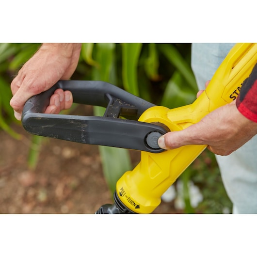 STANLEY SFMCST933M1 yellow and black handle close-up, garden tool adjustment in use.