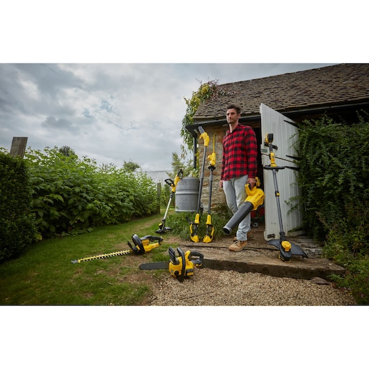 STANLEY SFMCST933M1 garden tools set in outdoor photography, including trimmer, blower, and hedge trimmer.