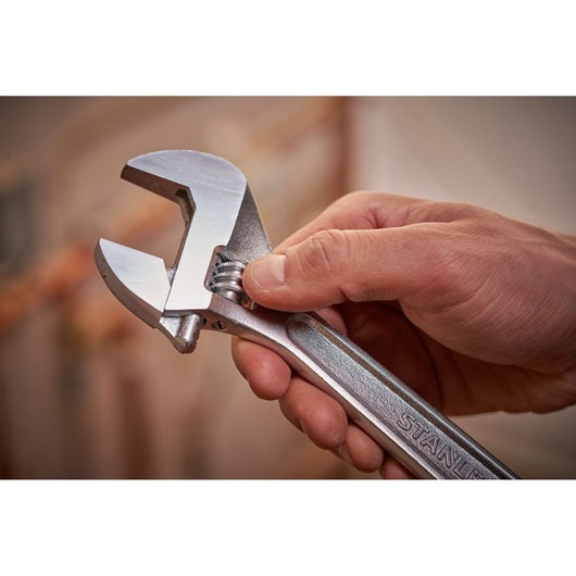 STANLEY STHT13122-0 adjustable wrench held in hand, silver finish, close-up photo.