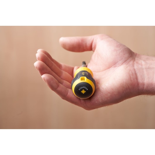 STANLEY STHT16196-0 yellow and black stubby screwdriver held in an open hand, side view.
