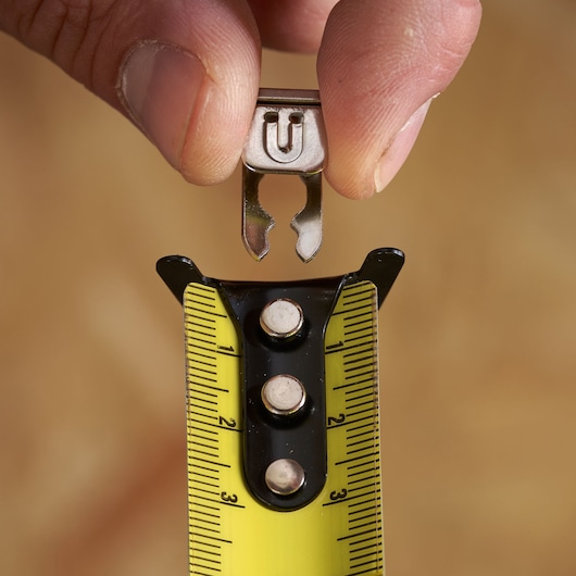 STANLEY STHT37232 tape measure close-up with yellow blade and accessory held by hand.