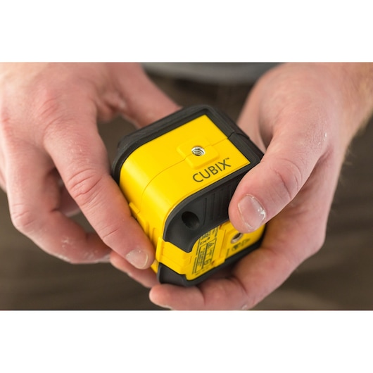 STANLEY STHT77499-1 photography of yellow Cubix laser level held in hands.