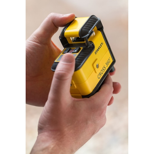 Photo of STANLEY STHT77504-1 CROSS 360 laser level held in hands, yellow and black exterior.