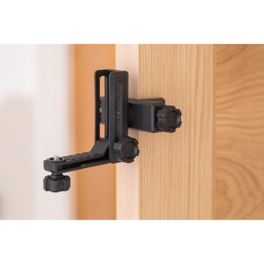 STANLEY STHT77504-1 black adjustable photography clamp attached to wooden door, side view.