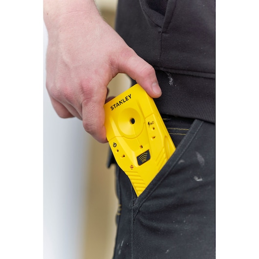 STANLEY STHT77587-0 yellow electronic stud finder held near pocket, close-up photography.