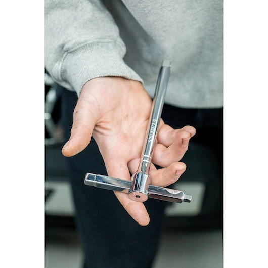 STANLEY STHT80872-0 T-handle tap wrench held in hand, chrome finish, photography close-up.
