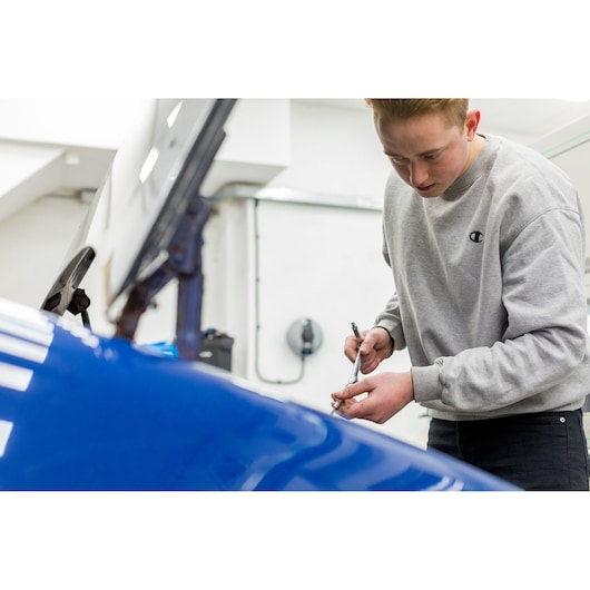 STANLEY STHT81015-0 ratchet in use by person working on blue car engine, indoor workshop setting.