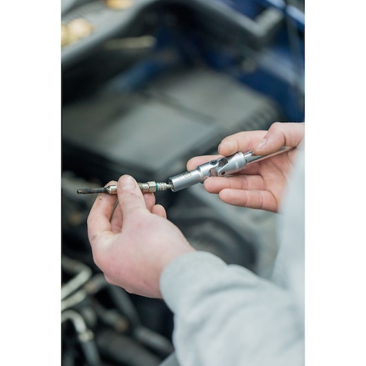 STANLEY STHT81016-0 socket wrench in use on spark plug, close-up photo showing tool detail.