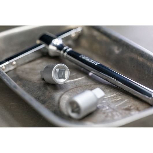STANLEY STHT81581-0 T-handle socket wrench and two sockets on metal tray, close-up angle.