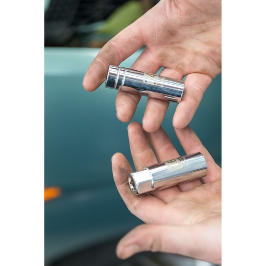 Photo of STANLEY STHT81582-0 chrome sockets held in dirty hands, automotive context, close-up view.