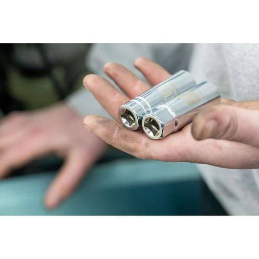 Photo of STANLEY STHT81582-0 chrome sockets held in a mechanic’s hand, close-up view.