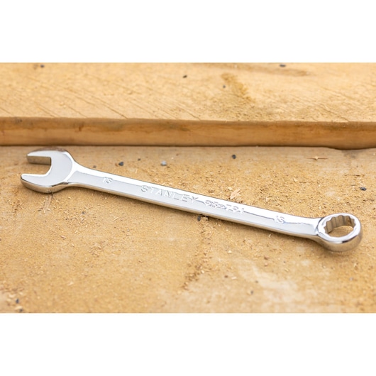 STANLEY STMT82842-0 combination wrench on wood surface, showing open and box ends with chrome finish.