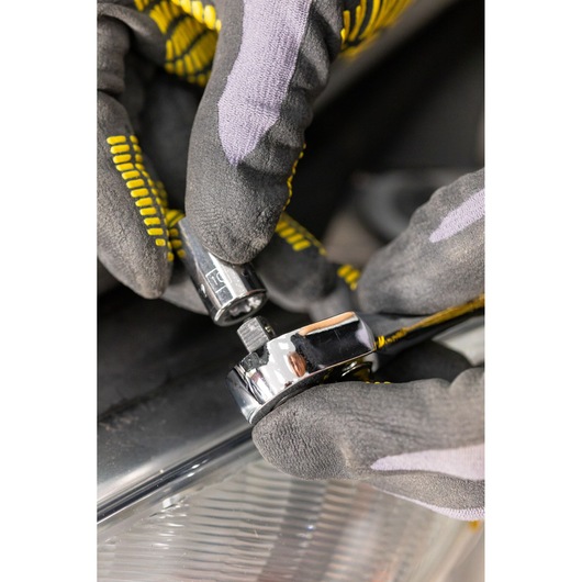 STANLEY STMT86103-0 photography of hand in glove attaching socket to chrome ratchet wrench.