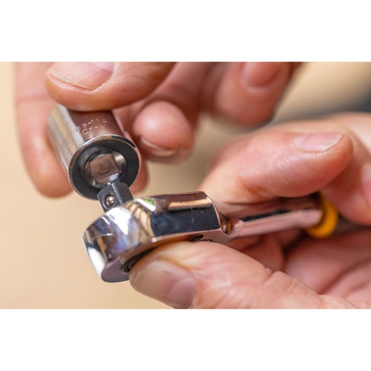 STANLEY STMT86303-0 close-up photo of a hand attaching a socket to a ratchet wrench, tools in use.