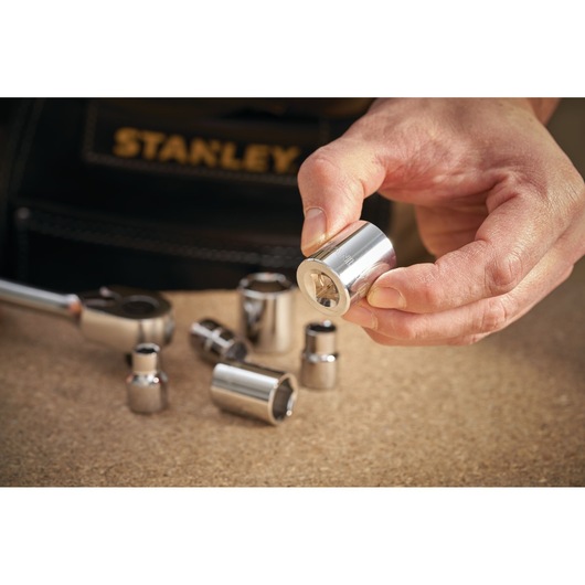 STANLEY STMT86308-0 socket set with metallic sockets, close-up on a hand holding a socket.