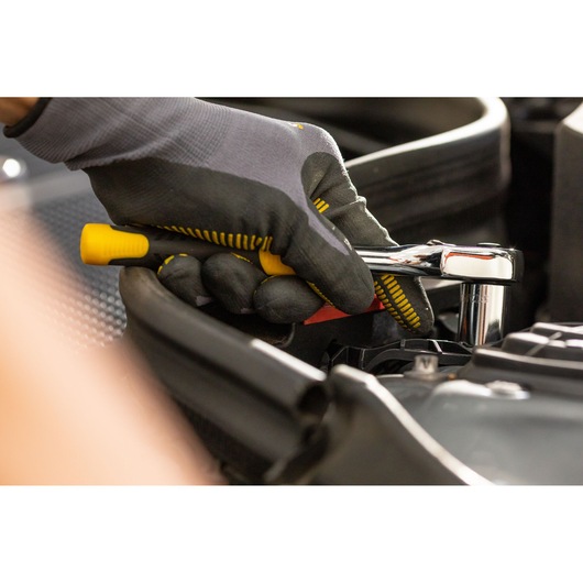 Photo of STANLEY STMT86314-0 ratchet handle in use, close-up view, mechanic’s gloved hand turning tool.