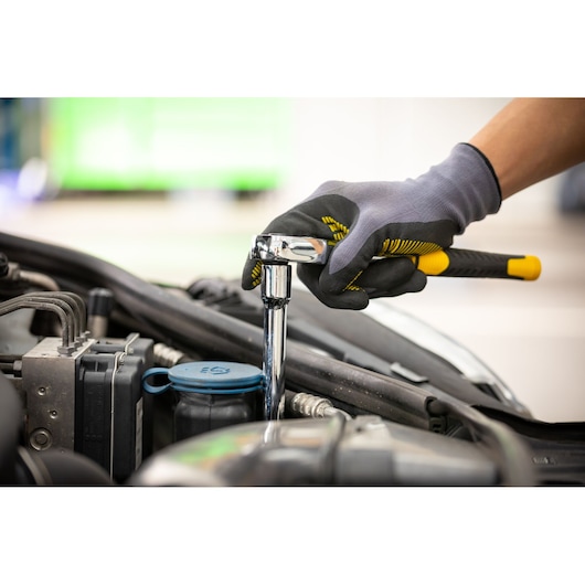Photo of STANLEY STMT88930-0 ratchet wrench in use, tightening bolt in car engine compartment.