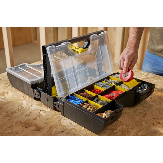 STANLEY STST1-71963 organizer box with clear lid and yellow compartments, photo of hand picking red tape.