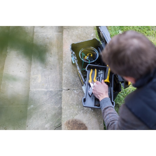 STANLEY STST1-75521 toolbox with yellow-handled pliers and screwdriver, outdoor top view.