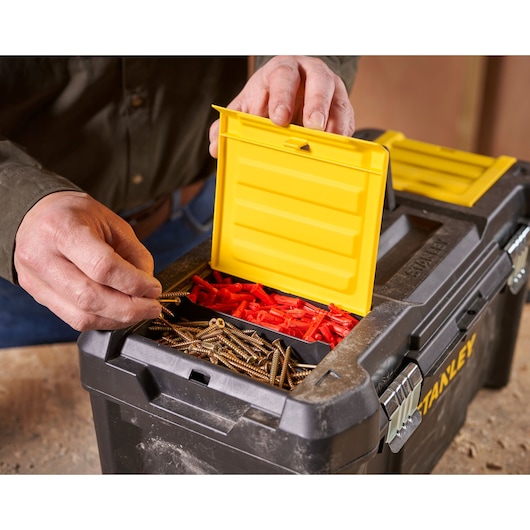 STANLEY STST1-75521 toolbox close-up with yellow lid open, showing screws and wall plugs inside.