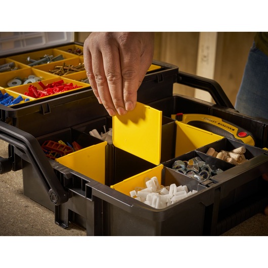 STANLEY STST1-75540 organizer box with yellow compartments, hand adjusting divider, close-up angle.