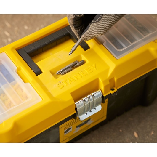 STANLEY STST75785-1 toolbox with yellow lid, metal latch, and screwdriver bits, close-up photo.