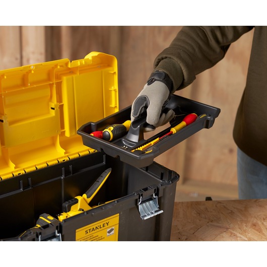 STANLEY STST75787-1 tool box with yellow lid, removable tray, hand holding tray with tools, side angle