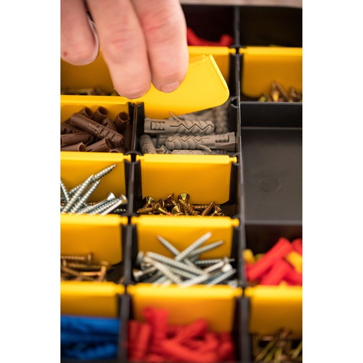 STANLEY STST81680-1 photography of hand opening yellow bin with assorted screws and wall plugs.