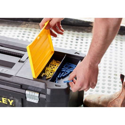 STANLEY STST82976-1 toolbox with open yellow lid showing compartments of blue and yellow wall plugs, close-up angle.