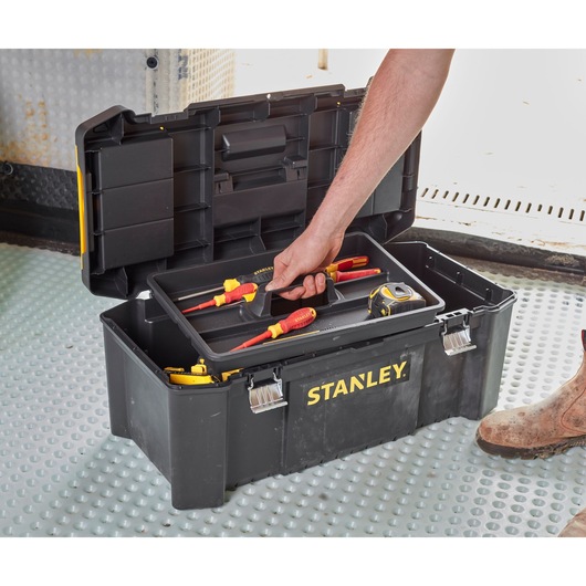 STANLEY STST82976-1 tool box with open lid, tray holding screwdrivers and tape measure on industrial floor.