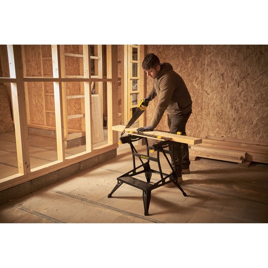 STANLEY STST83400-1 sawhorse in use, supporting wood plank in construction site.
