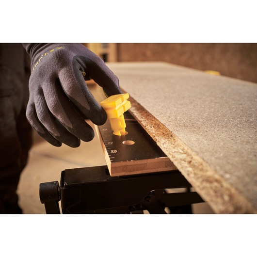 STANLEY STST83400-1 photography of gloved hand adjusting yellow clamp on workbench with wood board.